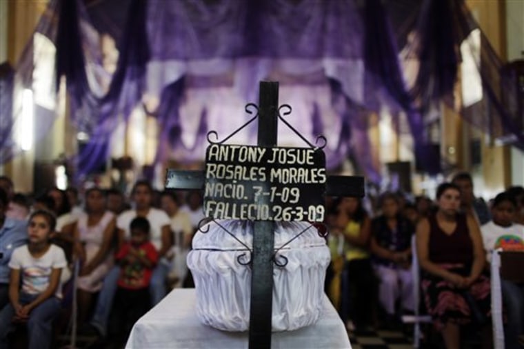 A cross leans against a coffin containing the body of two-month-old baby Antony Rosales Morales, who was killed during an attack against a public bus, during his March 27, 2009 wake in Guatemala City. In 2010, nearly half the territory in the country of 14 million is controlled by drug gangs and other criminals, with violence even at the capital's swankiest addresses. 